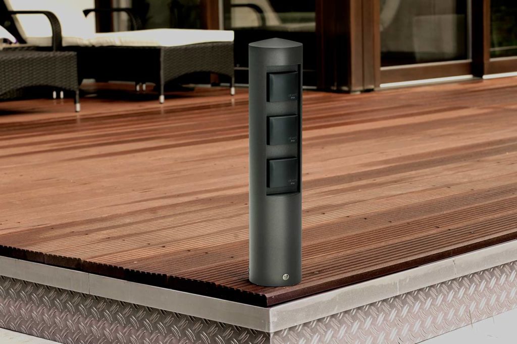 A socket column provides electricity on a wooden terrace.