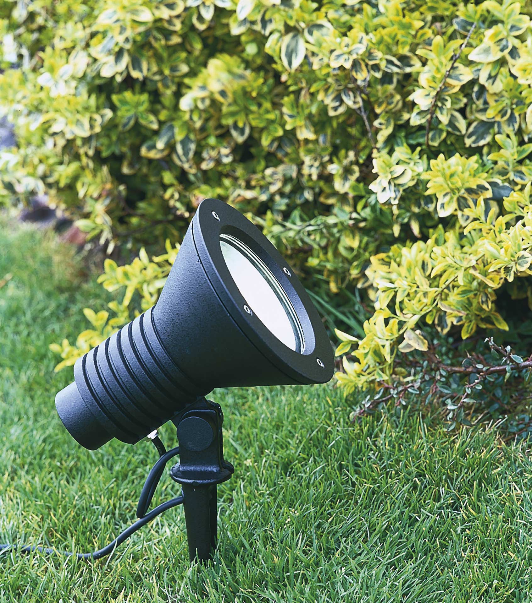 Eine LED-Strahler mit Erdspieß in einer Gartenanlage