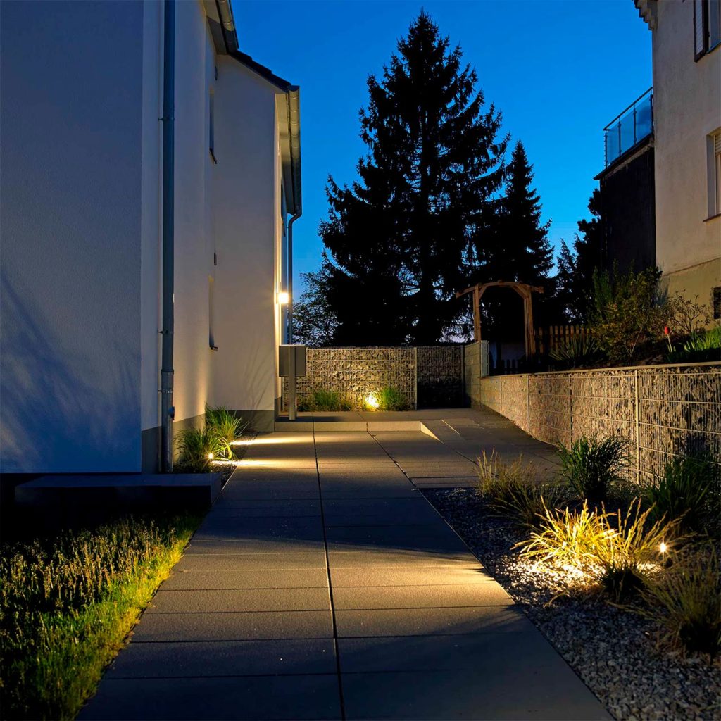 Beautiful theme worlds: a driveway illuminated with Albert lights at dusk.