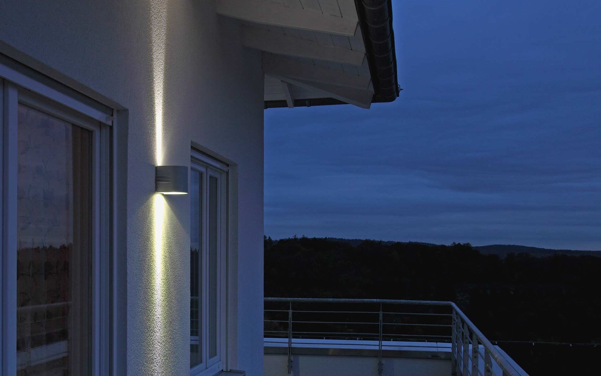 A wall lamp with double-sided light output stylishly sets off a balcony.